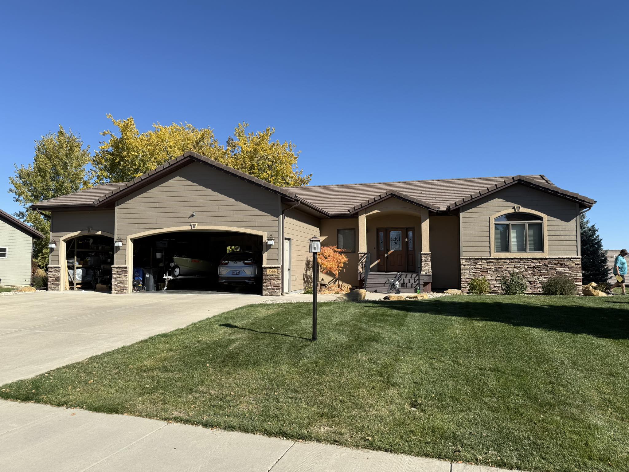 Tan ranch-style home exterior with brown trim and stone accents